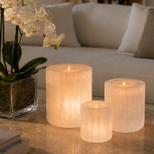 Load image into Gallery viewer, Hand-carved selenite candle holder beside a white orchid on a marble surface — THE NURA — LUXUL COLLECTIVE